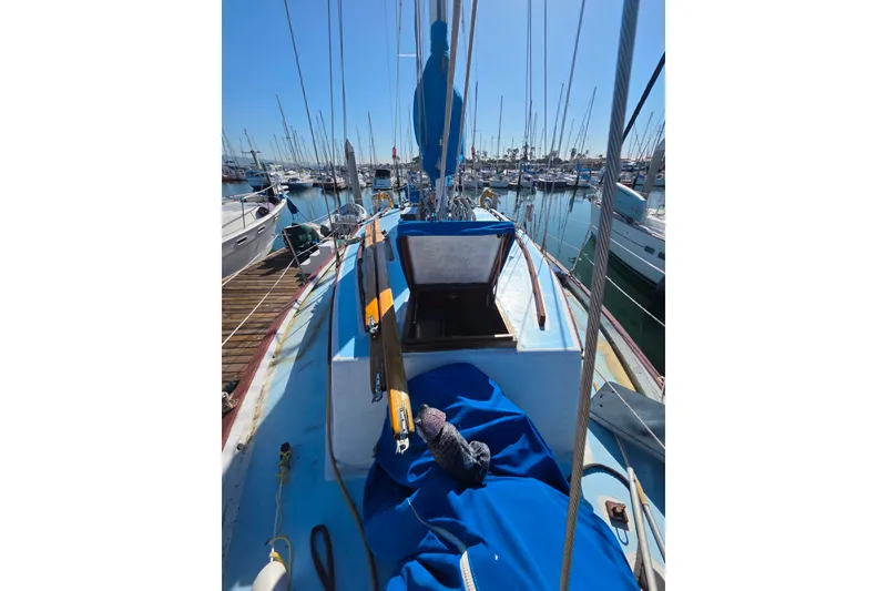 Slide: The Image of Sailboat Glen-L 44, 2006 model, docked in marina with blue covers and open hatch. - 103