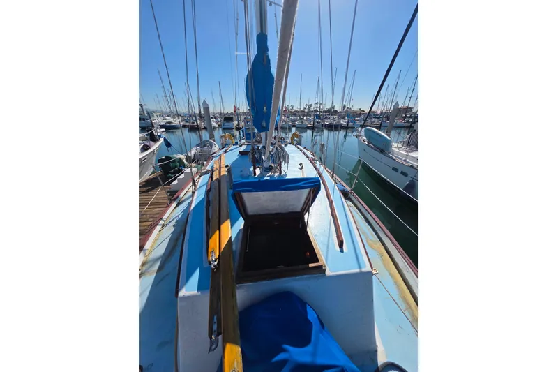 Slide: The Image of 2006 Glen-L 44 sailboat docked in marina, blue deck, open hatch, sunny day. - 107