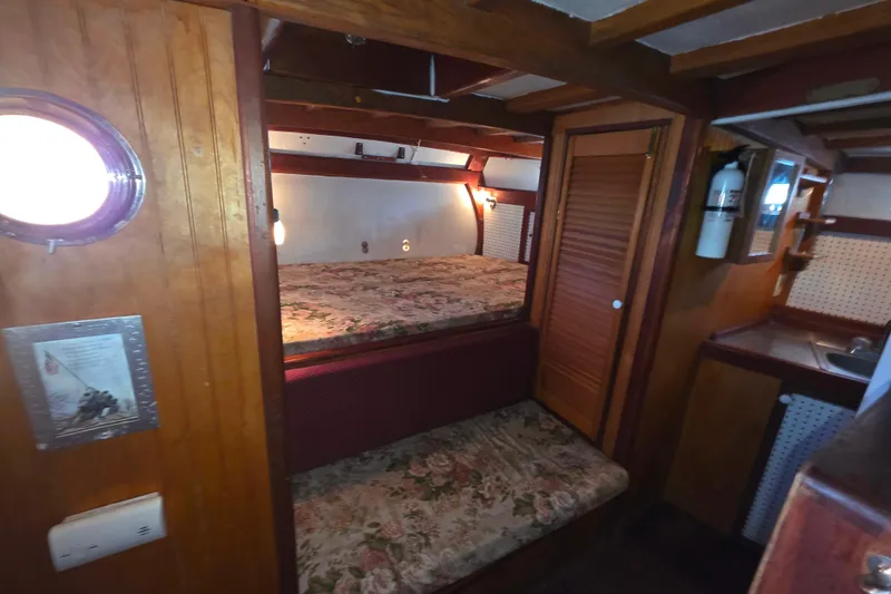 Slide: The Image of Cozy Glen-L 44 boat interior with wooden paneling and floral bedding, 2006 model. - 13