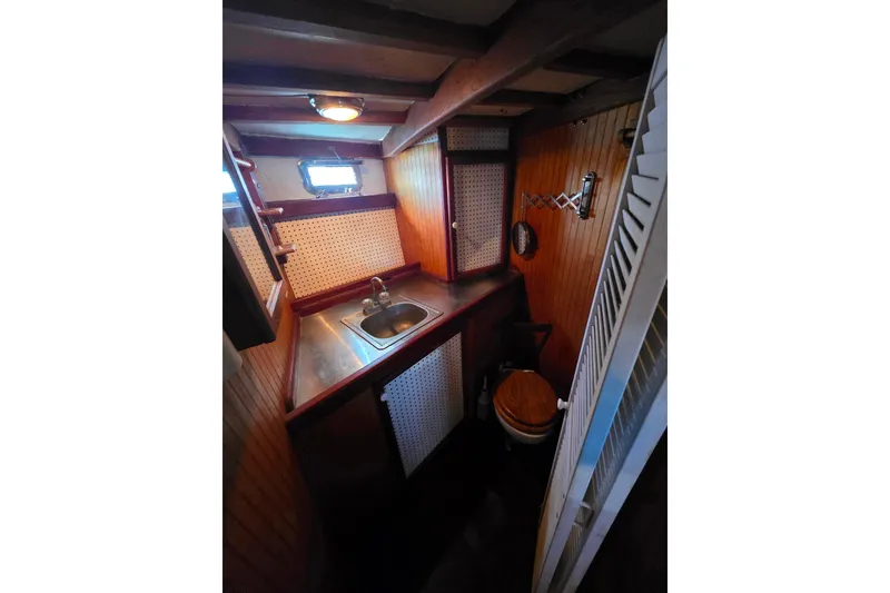Slide: The Image of Compact wooden boat bathroom with sink, toilet, and porthole window in 2006 Glen-L 44. - 17