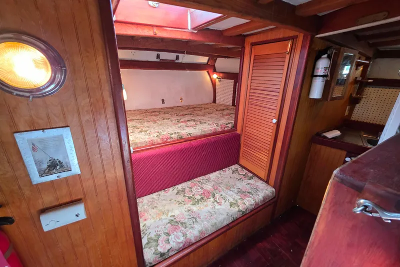 Slide: The Image of Interior of 2006 Glen-L 44 boat with floral bunk beds and wooden paneling. - 23