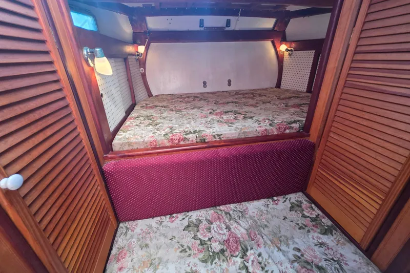 Slide: The Image of Cozy cabin interior of 2006 Glen-L 44 with floral bedding and wooden accents. - 24