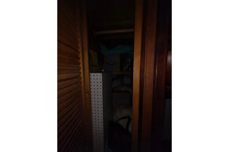 Slide: The Image of Dark wooden closet interior with shelves, featuring various stored items. Glen-L 44, 2006 model. - 27