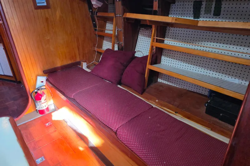 Slide: The Image of Cozy Glen-L 44 boat interior with cushioned seating, wooden shelves, and a fire extinguisher. - 37
