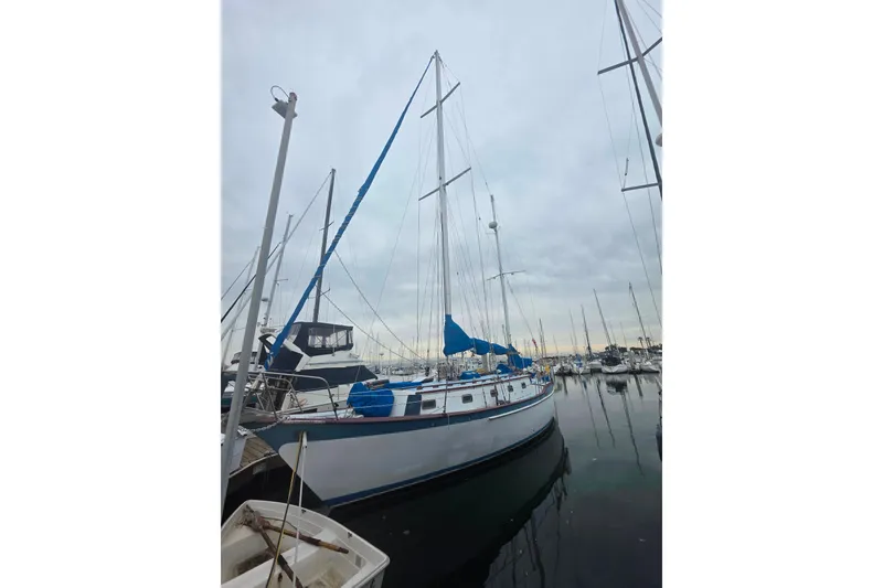 Slide: The Image of Sailboat Glen L 44, 2006 model, docked in a marina under cloudy skies. - 4