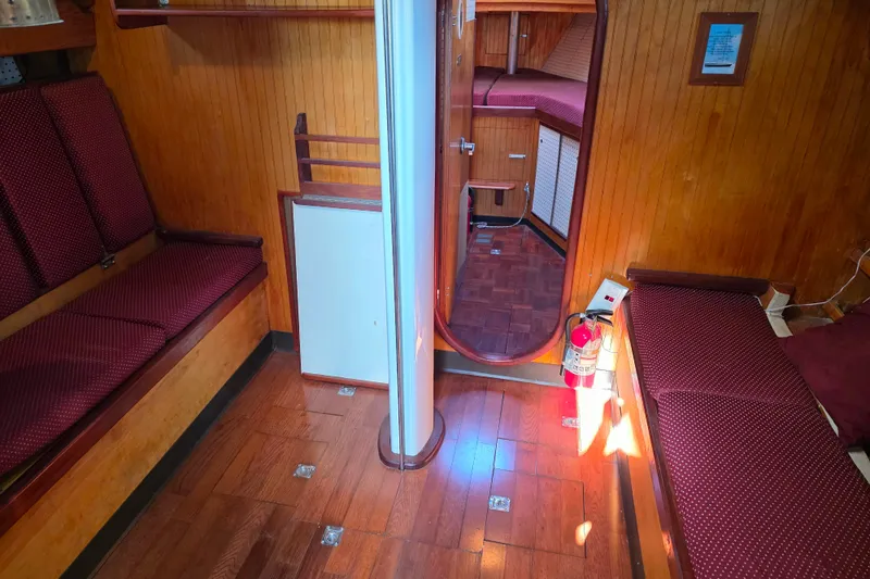Slide: The Image of Interior of 2006 Glen-L 44 boat with wooden paneling and red cushioned seating. - 47