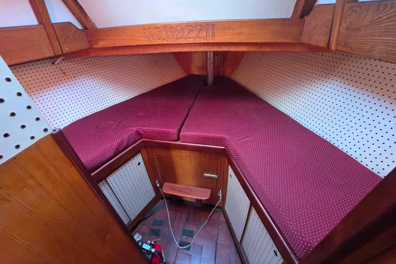 Slide: The Image of Cozy cabin interior of 2006 Glen-L 44 boat with red cushions and wood paneling. - 52