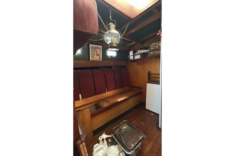 Slide: The Image of Cozy interior of 2006 Glen L 44 boat with vintage decor and wooden seating. - 6