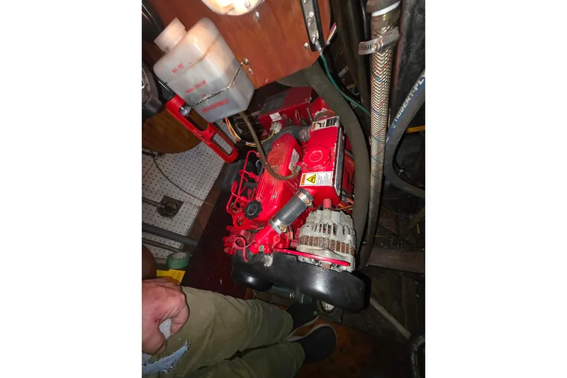 Slide: The Image of Red engine in a 2006 Glen-L 44 boat, surrounded by hoses and components. - 69