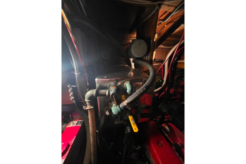 Slide: The Image of Engine compartment of a 2006 Glen-L 44 boat with visible hoses and components. - 70