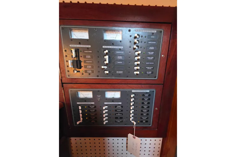 Slide: The Image of Electrical control panel on a 2006 Glen-L 44 boat, featuring switches and meters. - 86