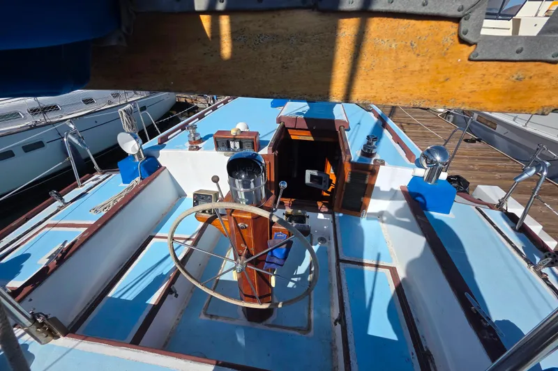 Slide: The Image of Cockpit of a 2006 Glen-L 44 sailboat with wooden steering wheel and blue accents. - 94