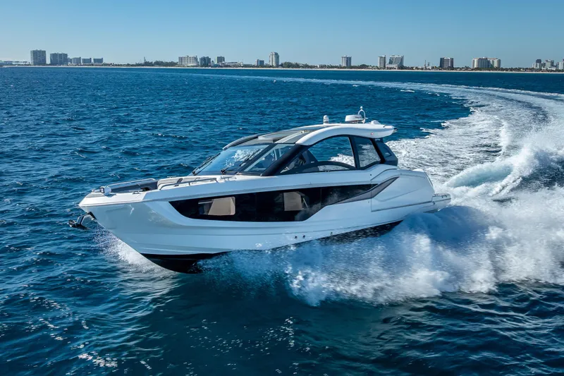 The Image of 2023 Galeon 375 GTO yacht cruising on open water near city skyline. - 0