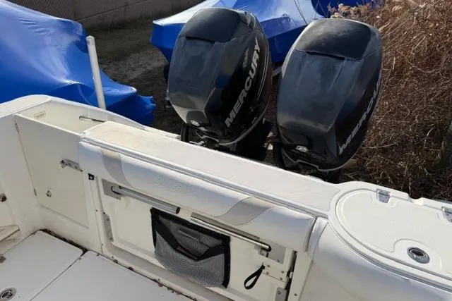 Slide: The Image of 2008 Boston Whaler 270 Outrage with dual Mercury outboard engines, docked and covered. - 11