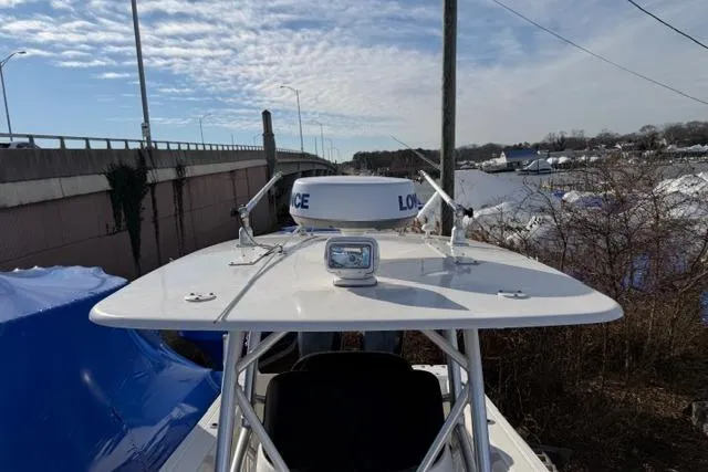Slide: The Image of 2008 Boston Whaler 270 Outrage boat with radar and spotlight, docked near a bridge. - 16