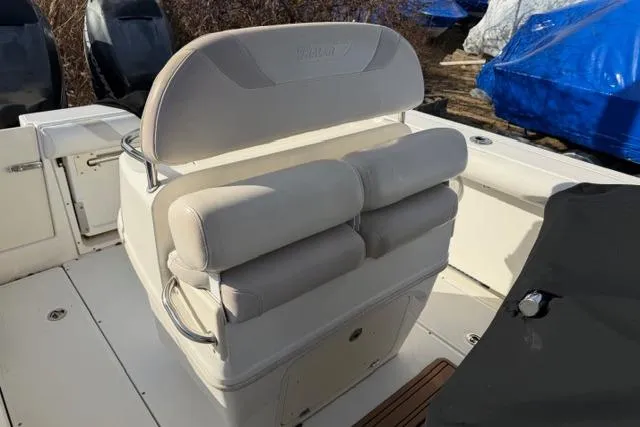 Slide: The Image of 2008 Boston Whaler 270 Outrage boat seating area with cushioned bench and storage. - 20