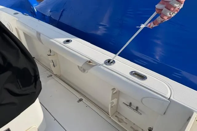 Slide: The Image of 2008 Boston Whaler 270 Outrage boat deck with blue cover and rod holders. - 9