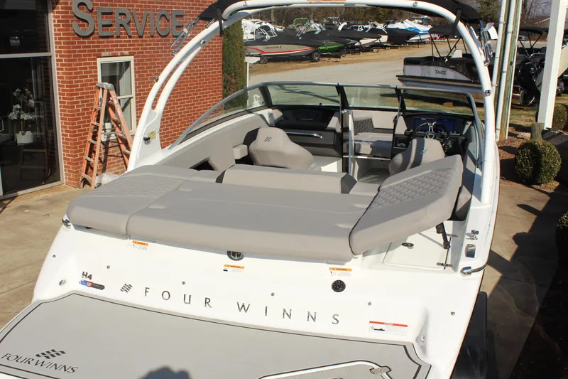 Slide: The Image of 2026 Four Winns H4 boat with sleek design, displayed outdoors near service center. - 14