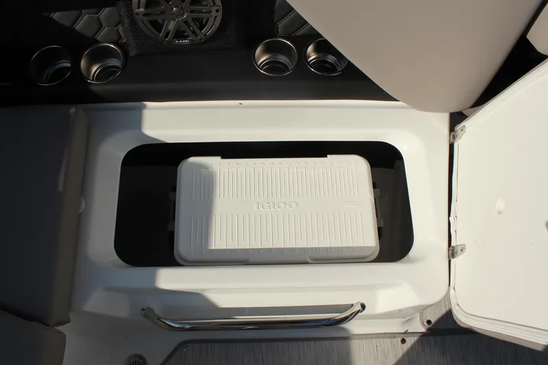 Slide: The Image of 2026 Four Winns H4 boat storage compartment with Igloo cooler and cup holders. - 15