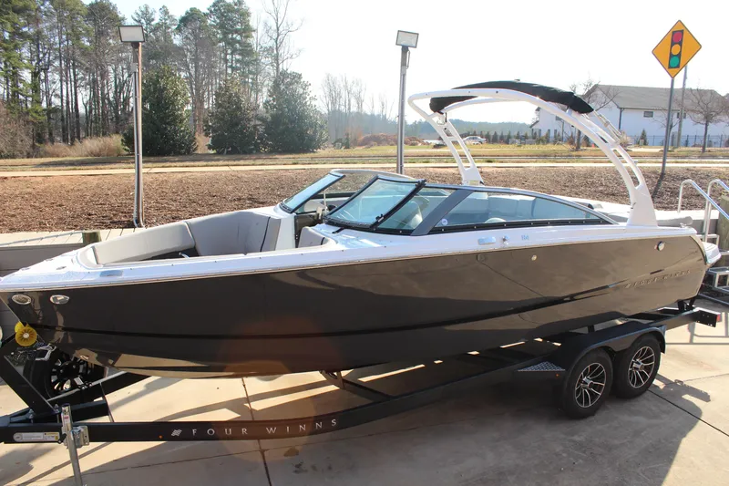 Slide: The Image of 2026 Four Winns H4 boat on trailer, sleek design, parked outdoors. - 25