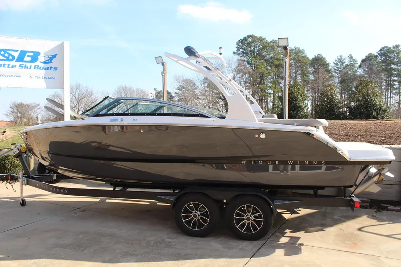 Slide: The Image of 2026 Four Winns H4 boat on trailer at dealership, sunny day. - 26