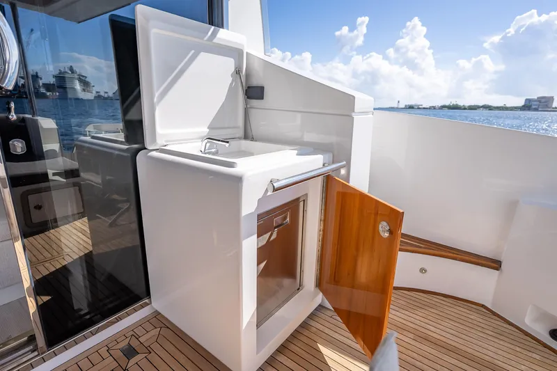 Slide: The Image of Outdoor kitchenette on 2019 Azimut 66 yacht with sink and storage, overlooking ocean. - 115