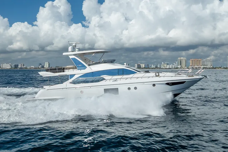 Slide: The Image of 2019 Azimut 66 yacht cruising on ocean with city skyline in background. - 21