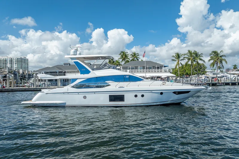Slide: The Image of 2019 Azimut 66 yacht docked in a marina, surrounded by palm trees and buildings. - 26