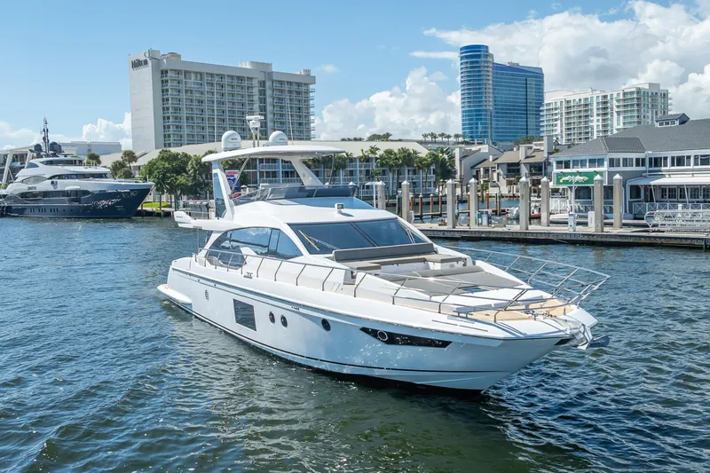 Slide: The Image of Luxury 2019 Azimut 66 yacht docked in a marina with modern buildings in the background. - 27