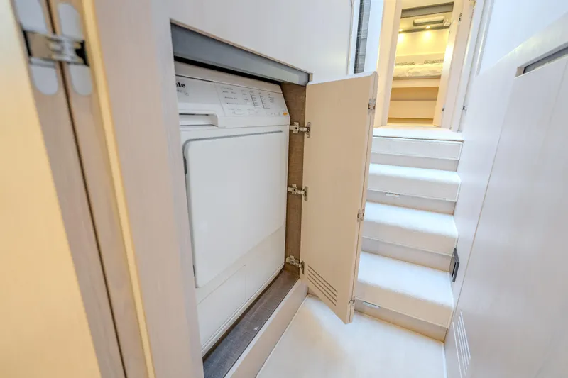 Slide: The Image of Laundry area inside 2019 Azimut 66 yacht, featuring a built-in washing machine. - 51
