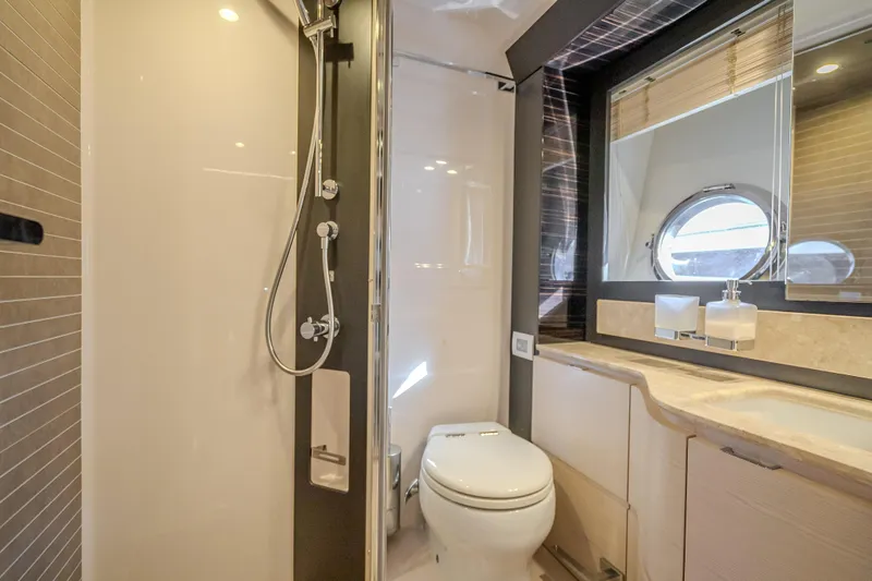 Slide: The Image of Luxurious bathroom in 2019 Azimut 66 yacht with shower, toilet, and porthole window. - 77