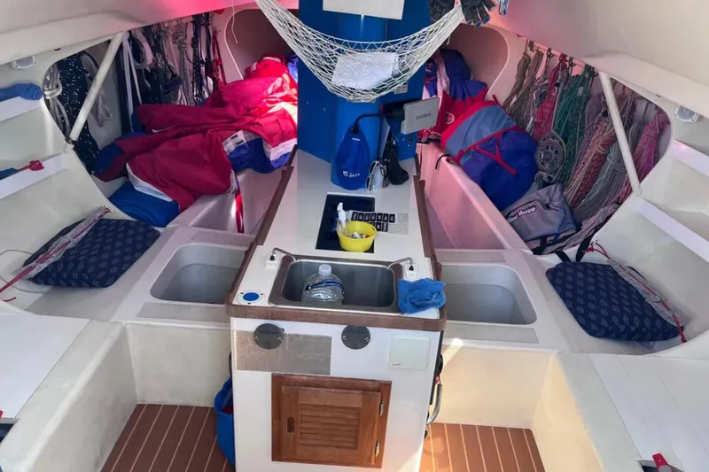 Slide: The Image of Interior of 2009 Class 40 Open Antrim sailboat with organized gear and compact kitchen area. - 21