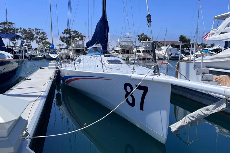 Slide: The Image of Sleek 2009 Class 40 Open Antrim Design sailboat docked in a marina, numbered 87. - 3