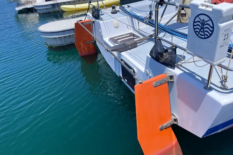 Slide: The Image of 2009 Class 40 Open Antrim Design sailboat docked, featuring vibrant orange rudders. - 6