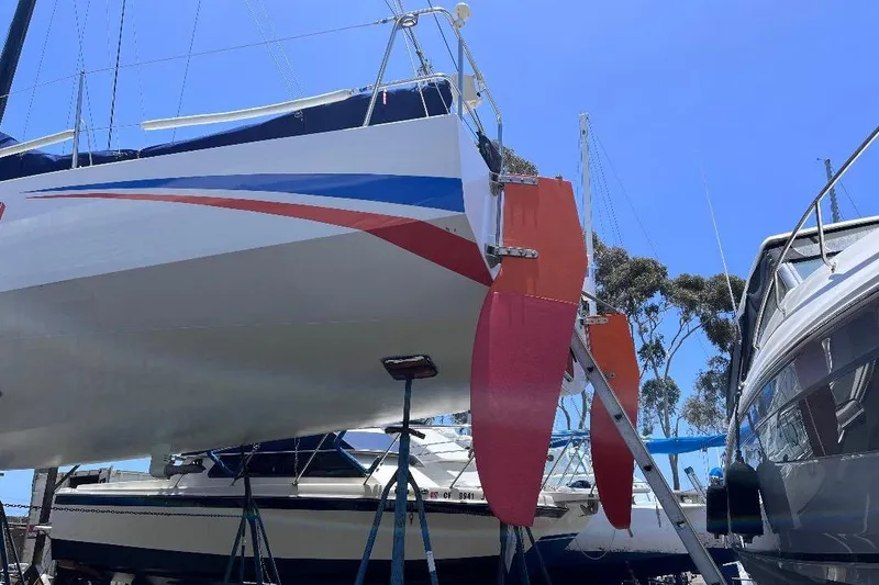 Slide: The Image of 2009 Class 40 Open Antrim Design sailboat with vibrant red and blue accents in a marina. - 7