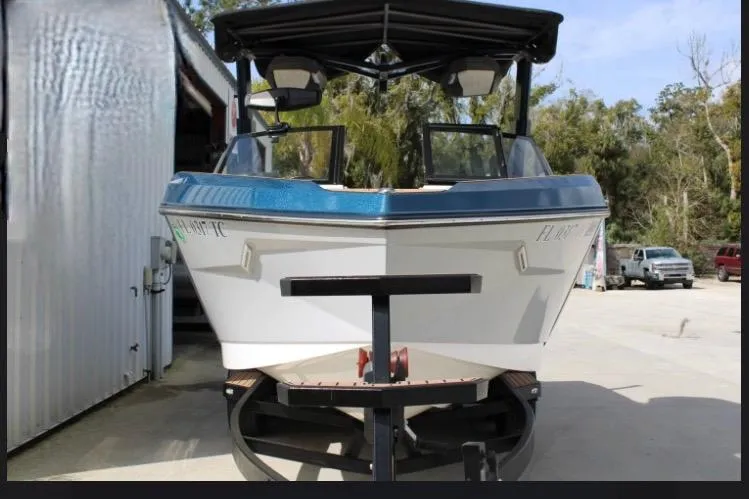 Slide: The Image of 2022 Nautique Super Air Nautique S23 boat on trailer, front view, outdoors. - 19