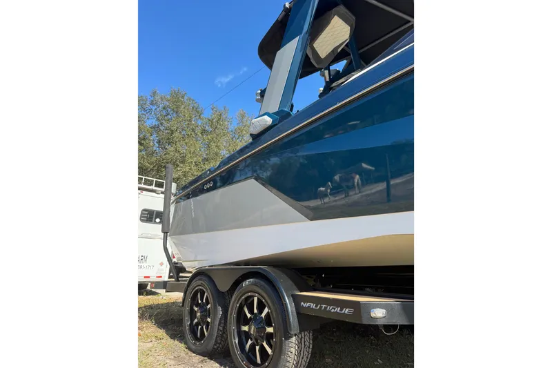 Slide: The Image of 2022 Nautique Super Air Nautique S23 boat on trailer, side view. - 21