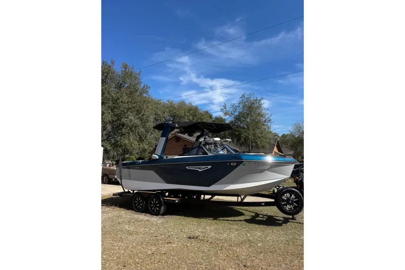 Slide: The Image of 2022 Nautique Super Air Nautique S23 boat on trailer under clear blue sky. - 22