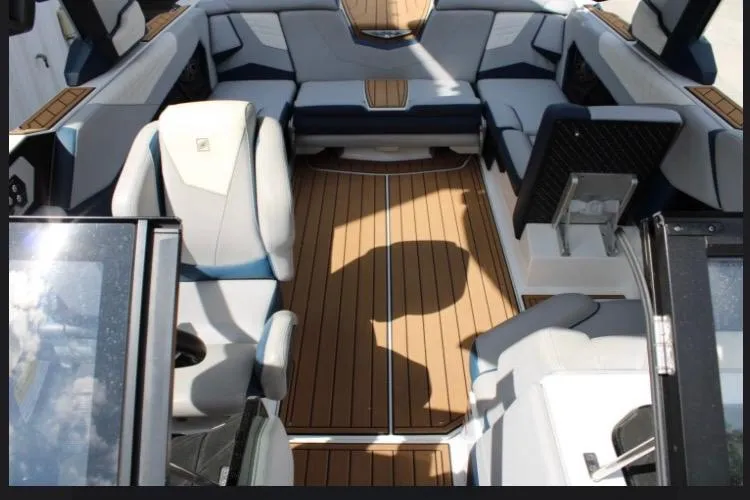 Slide: The Image of 2022 Nautique Super Air Nautique S23 interior with luxurious seating and teak flooring. - 4