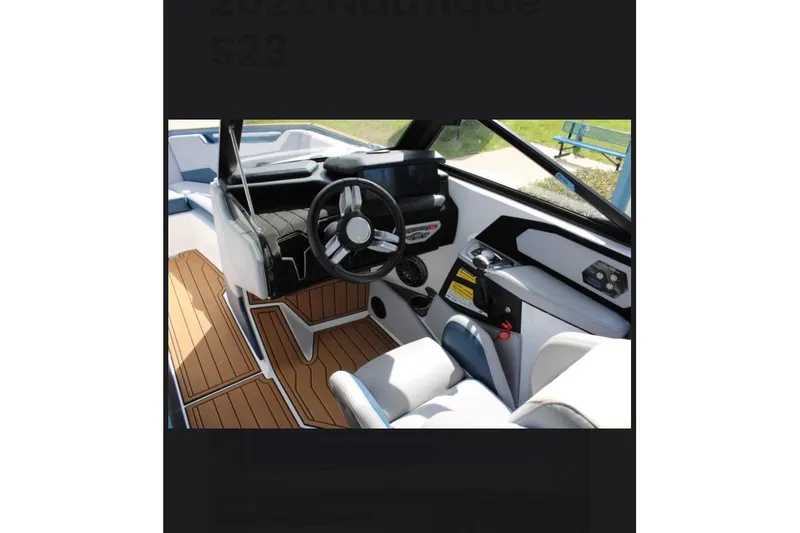 Slide: The Image of Interior of 2022 Nautique Super Air Nautique S23 boat with modern steering and seating. - 6