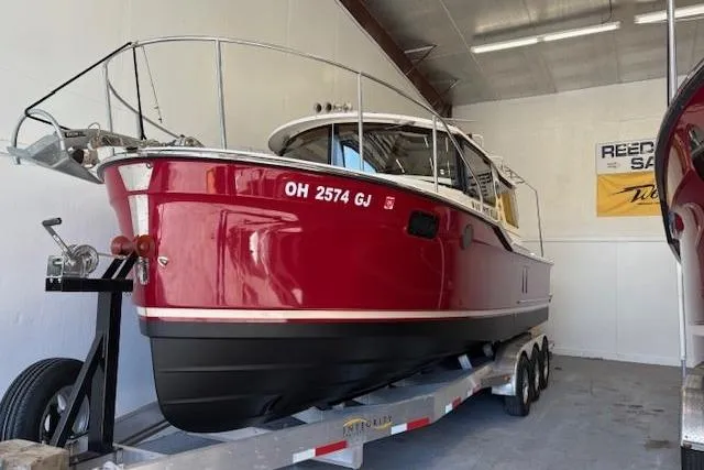 The Image of 2022 Ranger Tugs R-27 boat in red, on a trailer inside a storage facility. - 0
