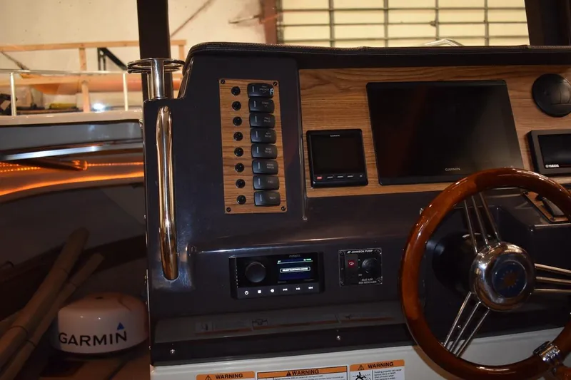 Slide: The Image of 2022 Ranger Tugs R-27 helm with Garmin navigation and wood accents. - 13