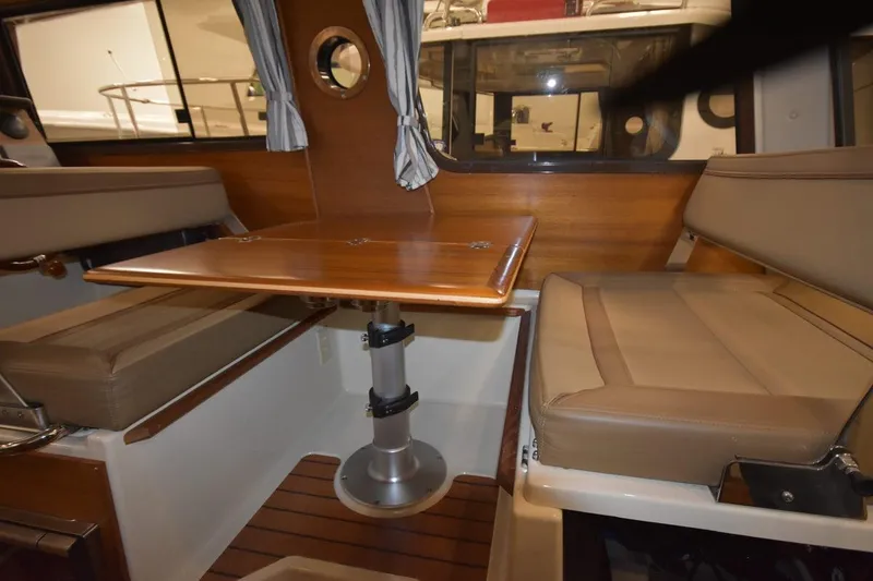 Slide: The Image of Interior of 2022 Ranger Tugs R-27 with wooden table and cushioned seating. - 17
