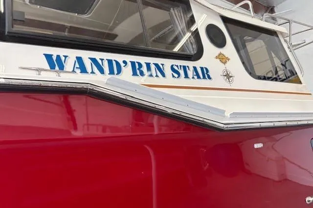 Slide: The Image of 2022 Ranger Tugs R-27 boat named "Wand'rin Star" with red and white exterior. - 4