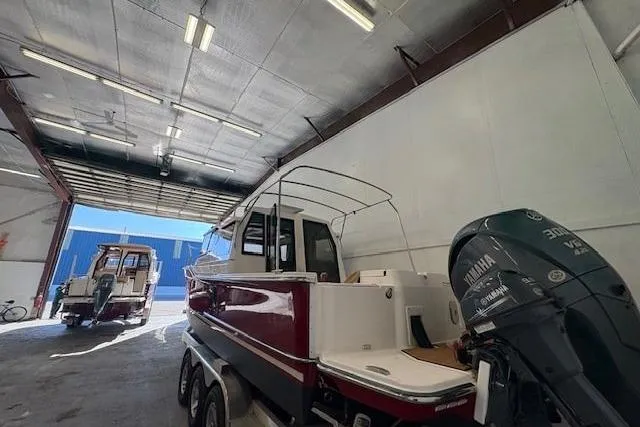 Slide: The Image of 2022 Ranger Tugs R-27 boat in a warehouse with Yamaha outboard motor. - 6