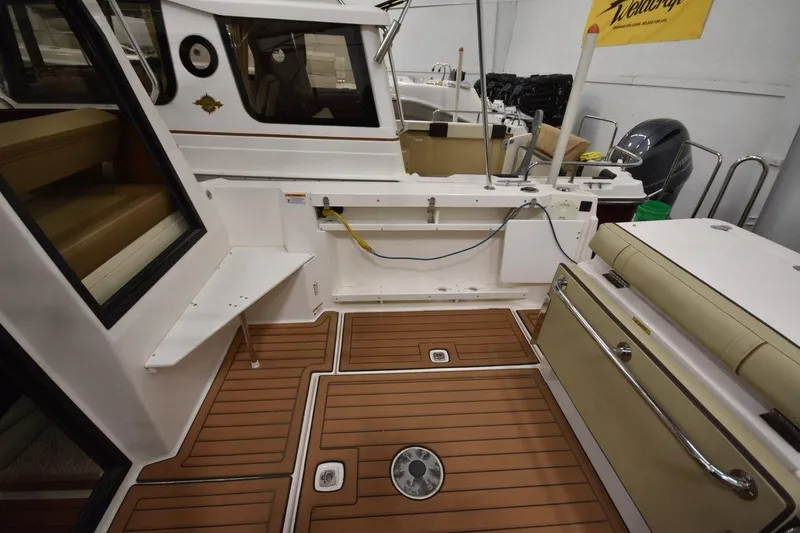 Slide: The Image of 2022 Ranger Tugs R-27 boat interior with teak flooring and seating area. - 9