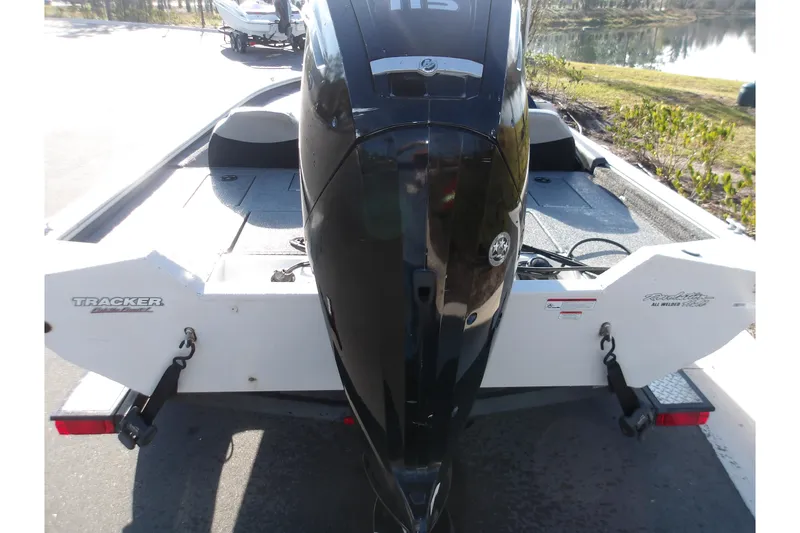 Slide: The Image of 2018 Tracker Pro Team 195 boat with powerful outboard motor, parked near a lake. - 5