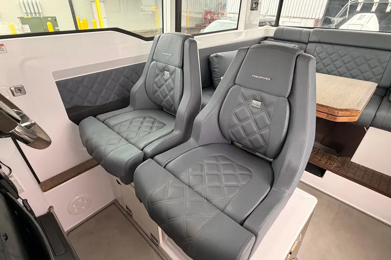 Slide: The Image of 2021 Axopar 37 XC Cross Cabin interior with luxurious gray seating and wooden table. - 14