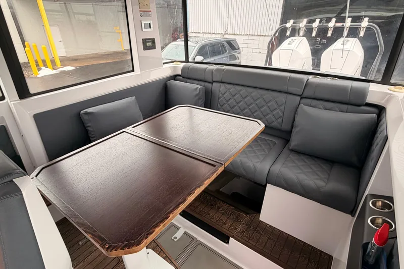Slide: The Image of Interior of 2021 Axopar 37 XC Cross Cabin with cushioned seating and wooden table. - 21