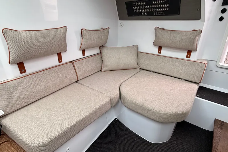 Slide: The Image of Interior seating of 2021 Axopar 37 XC Cross Cabin with beige cushions and wall panel. - 24